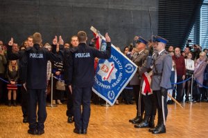 policjanci w trakcie ślubowania  w tle stoją zaproszeni goście