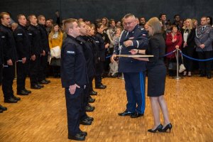 policjanci w trakcie ślubowania w tle zaproszeni goście komendant wojewódzki policji wręcza odznaczenia