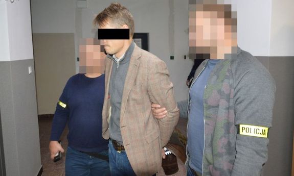 Zatrzymany mężczyzna w eskorcie dwóch policjantów