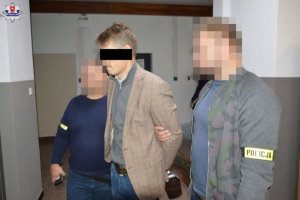 Zatrzymany mężczyzna w eskorcie dwóch policjantów