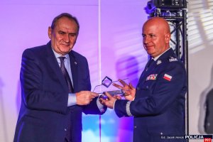 komendant główny policji i zaproszony gość trzymają szklane trofeum