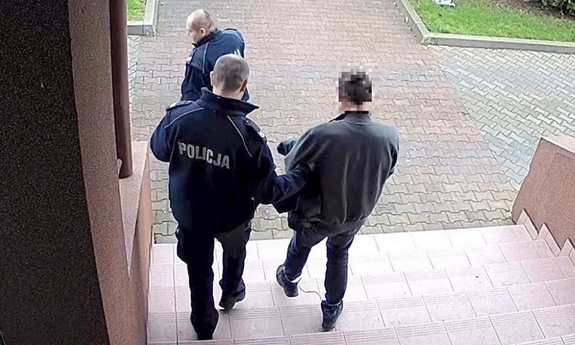 policjant prowadzi zatrzymanego mężczyznę