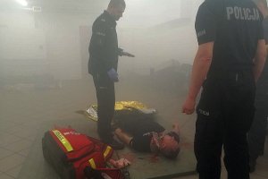 Instruktor przekazujący wskazówki policjantom, którzy za chwilę rozpoczną udzielanie pierwszej pomocy.