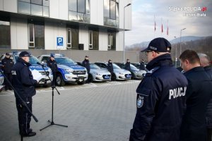 Policjanci, stojący obok samochodów