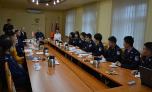 przedstawiciele wyższej szkoły policji w szczytnie oraz delegacja z chin w trakcie spotkania siedzą przy stole