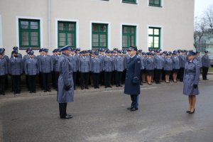 policjanci stojący w dwuszeregu, przed nimi policjant składa meldunek komendantowi-rektorowi