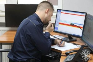 Policjant sporządzający notatkę przy komputerze
