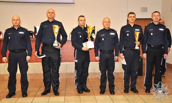 najlepsi dyżurni z pucharami w rękach, towarzyszą im Komendant Główny Policji oraz Komendant Szkoły Policji w Katowicach z policjantem