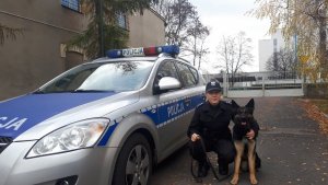 policjantka z psem policjnym obok radiowozu
