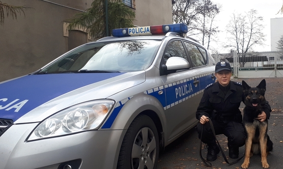 policjantka z psem policyjnym obok radiowozu