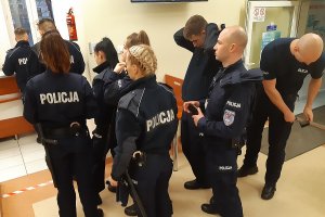 Policjanci w przy ladzie w kolejce do rejestracji.