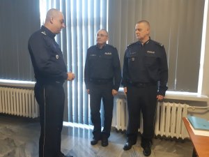 trzej policjanci uczestnicy narady rozmawiają stojąc