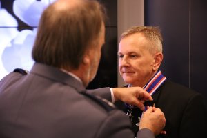 Koordynator Komendanta Głównego Policji ds. organizacji imprez sportowo-rekreacyjnych Andrzej Kuczyński przypina medal mężczyźnie