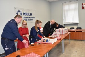 policjanci z pracownicy policji pakują prezenty