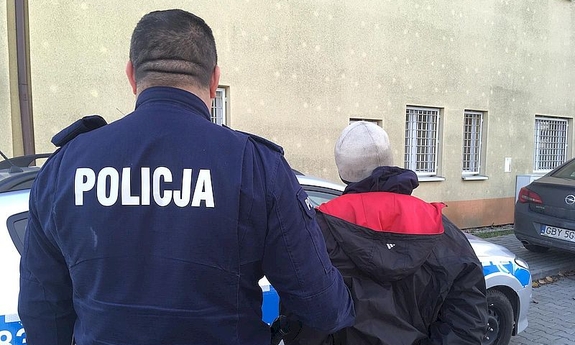 policjant prowadzi zatrzymanego mężczyznę