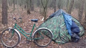 rower a obok namiot typu igloo do którego wchodzi mężczyzna