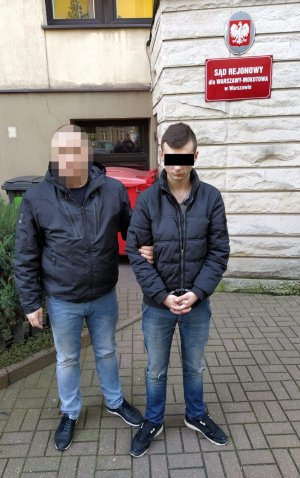 Policjant z zatrzymanym mężczyzną