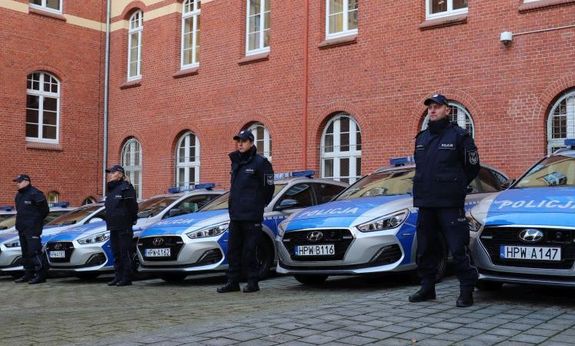 policjanci stoją przy nowych radiowozach