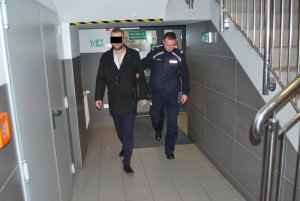 Policjant prowadzi zatrzymanego