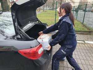 Policjantka pakuje prezenty do bagażnika samochodu