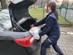 Policjantka pakuje prezenty do bagażnika samochodu