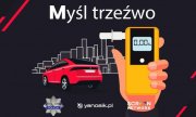 Napis: Myśl trzeźwo, czerwony samochód, w dłoni żółty alkomat na wyświetlaczu którego widnieje cyfra 0 promili, z tyłu zarys budynków, pod spodem logo Policji, yanosik.pl i Screen Network