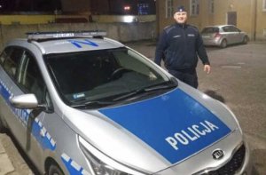 policjant stoi przy radiowozie