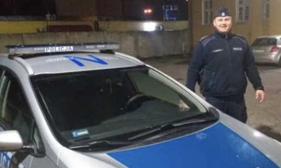 policjant stoi przy radiowozie