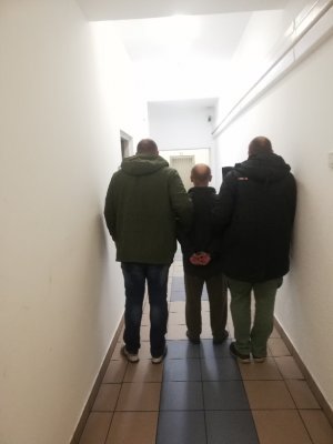 Policjanci wykonują czynności  z zatrzymanym mężczyzną