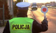 policjant ruchu drogowego z &quot;policyjnym lizakiem&quot; kontroluje zatrzymuje pojazdy na drodze