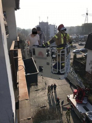 Policjant i strażak pożarny z zatrzymanym mężczyzną