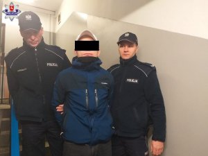 policjanci prowadzą zatrzymanego mężczyznę