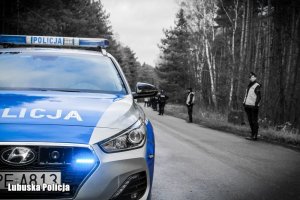 Radiowóz policyjny w tle policjanci