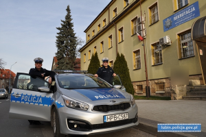 policjanci ruchu drogowego stoją przy radiowozie