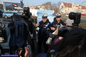 Policjanci stojący przed kamerami stacji telewizyjnych