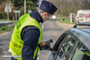 Policjant sprawdzający trzeźwość alkomatem