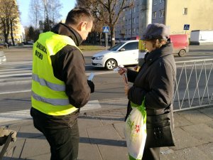 pracownik urzędu miasta rozdaje odblaski seniorom z okazji dnia babci i dziadka