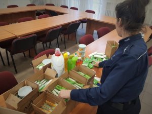 Policjantka pakuje do kartonów środki czystości