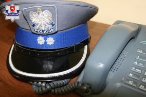 policyjna czapka leżąca przy telefonie stacjonarnym