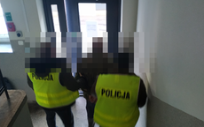 policjanci prowadzą zatrzymanego