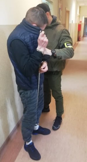 policjant z zatrzymanym mężczyzną