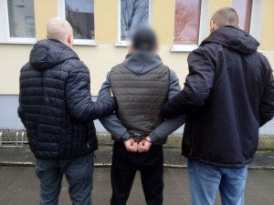 dwaj policjanci prowadzą zatrzymanego