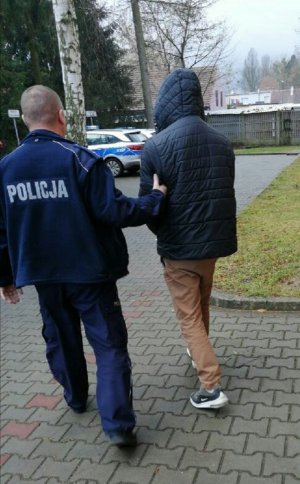 policjant prowadzi zatrzymanego