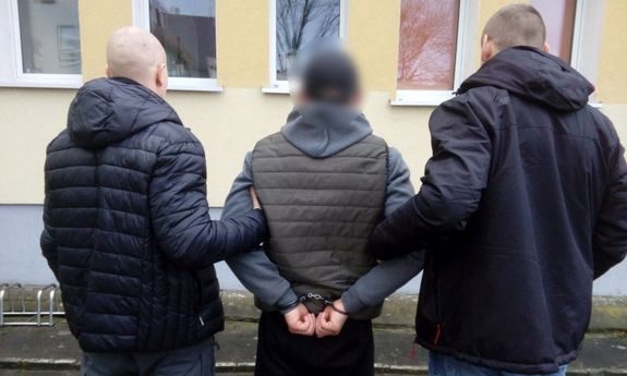 dwaj policjanci prowadzą zatrzymanego