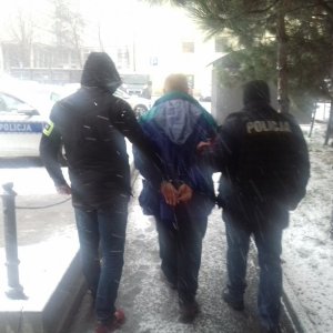 dwaj policjanci z zatrzymanym mężczyzną