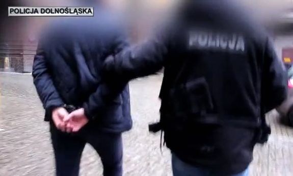 policjant prowadzi zatrzymanego