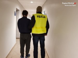 policjant prowadzi zatrzymanego