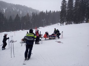 Umundurowani policjanci przy skuterze śnieżnym.