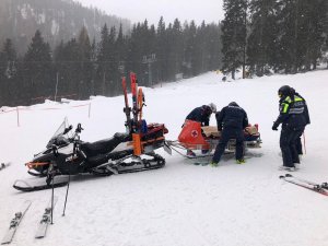 Policjanci zabezpieczają poszkodowana osobę na saniach.