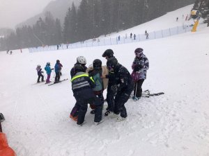 Umundurowani policjanci pomagają wstać poszkodowanemu.